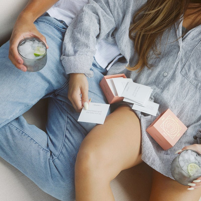 Couple snuggling together reading conversation cards