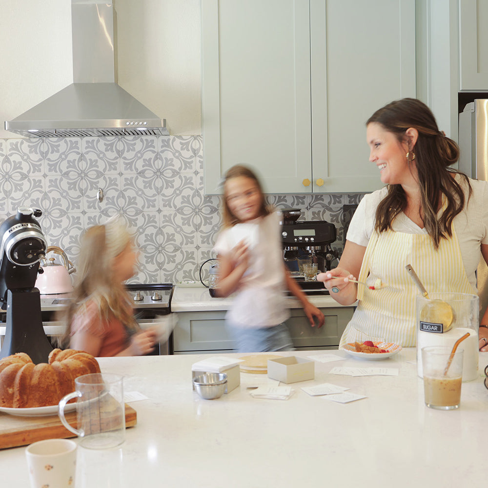 Young family in the kitchen baking together and reading conversation cards from Lumitory.