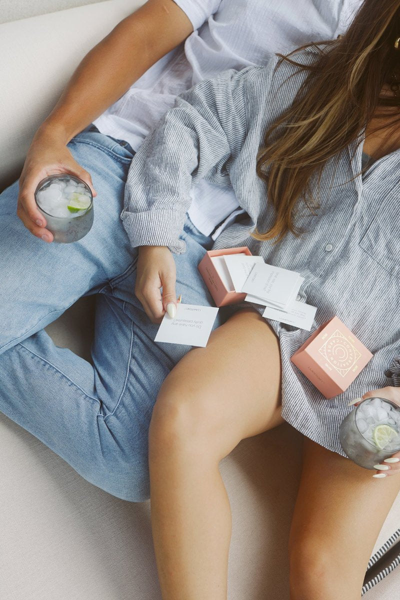 Couple snuggling together reading conversation cards