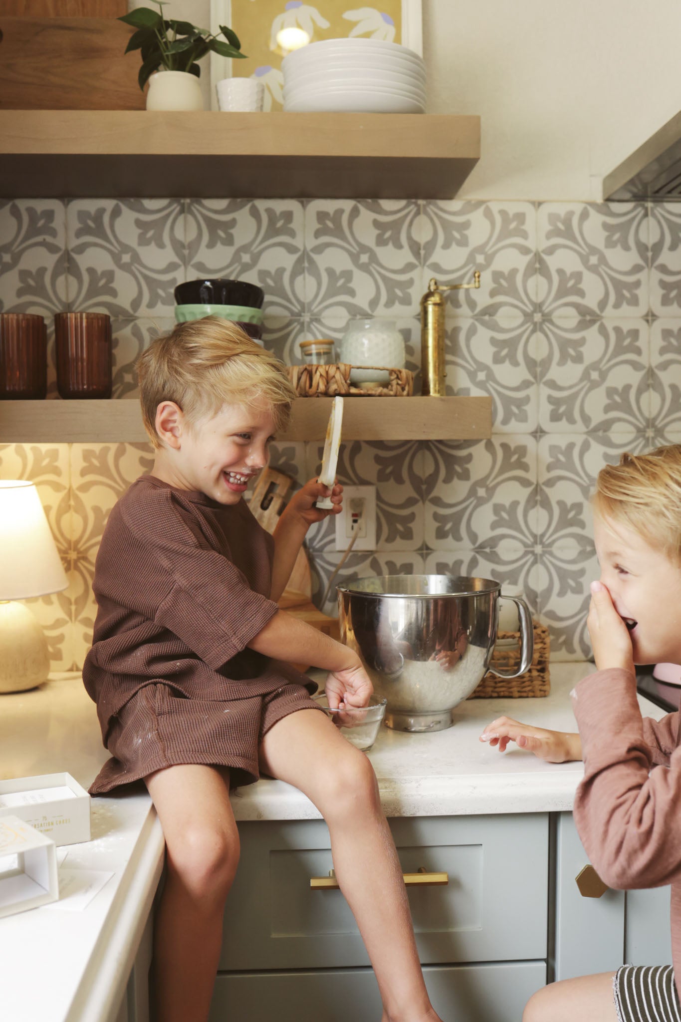 Kid sitting on the counter playing with dough 